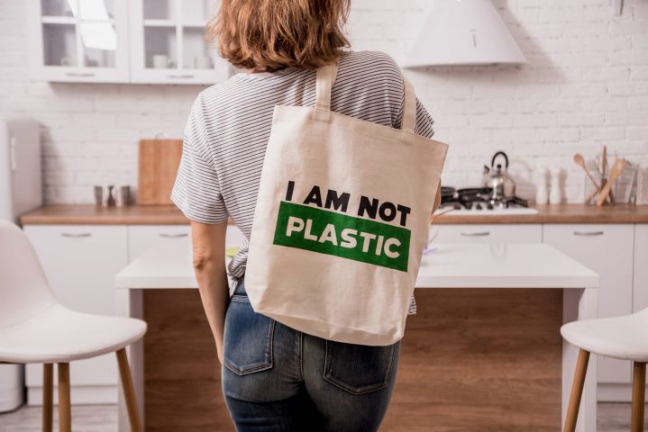 Young girl holding a cloth bag. At the kitchen. I am not plastic. Campaign to reduce the use of plastic bags. Zero waste concept